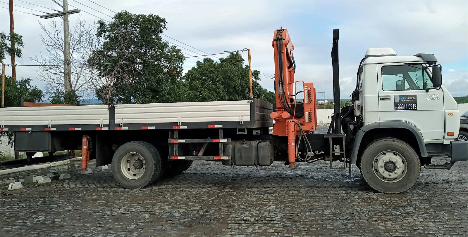 Caminhão munck da Becker Ferreira em perfil, carroceria de madeira