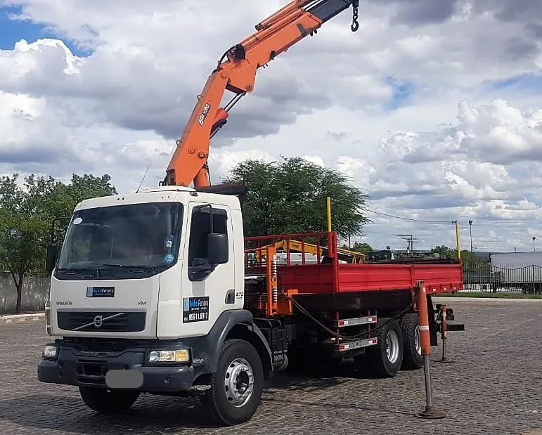 Caminhão munck Volvo com lança laranja, carroceria vermelha