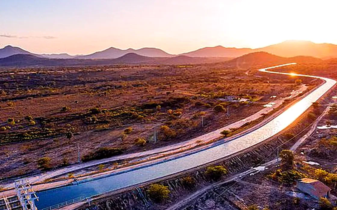 Vista aérea de um canal de transposição de água cortando a caatinga ao entardecer