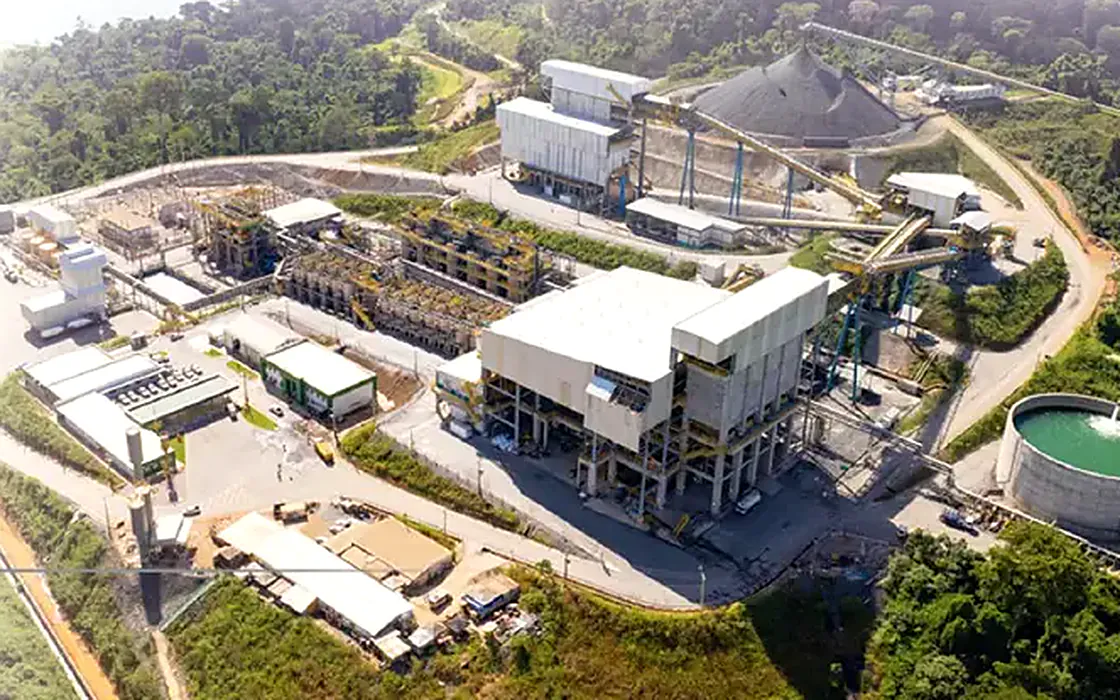 Vista aérea de uma planta de mineração, com galpões, correias transportadoras e pátio de britagem